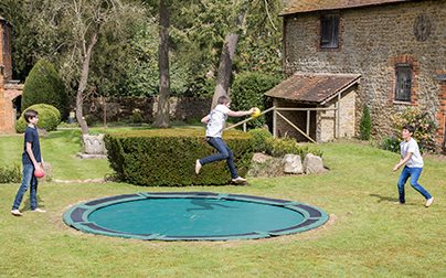 Kids playing on in-ground trampoline